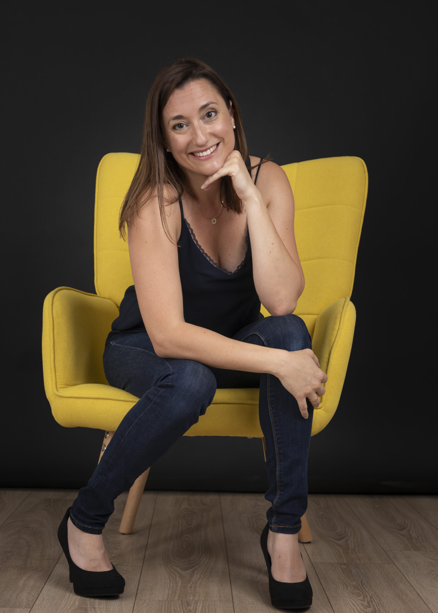 Femme assise sur un fauteuil jaune